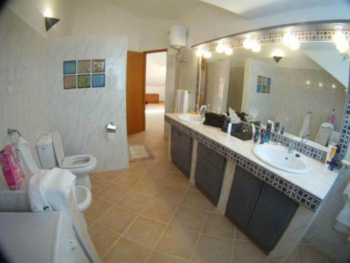 a bathroom with a sink and a toilet and a mirror at Casa Bahia 10 Grande Penthouse in Santa Maria