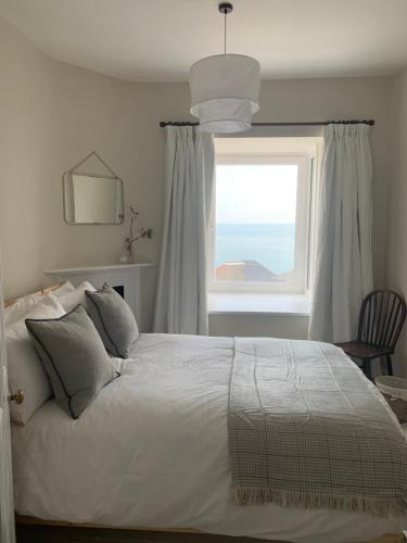 Schlafzimmer mit einem großen Bett und einem Fenster in der Unterkunft 28 North, Stunning Costal home with Generous Ferry Reduction in Ventnor