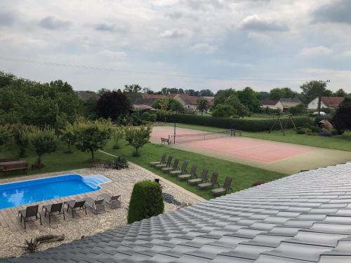 a swimming pool and a tennis court with chairs at U Fousáče in Hrabětice