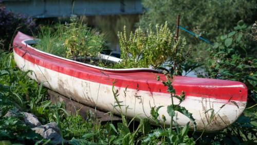 a red and white boat sitting in the grass at Penzion Betty in Okounov
