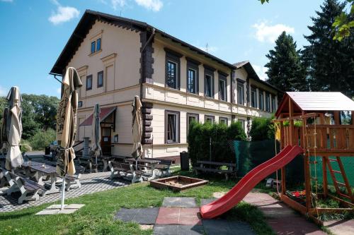 a house with a red slide and a playground at Penzion Betty in Okounov