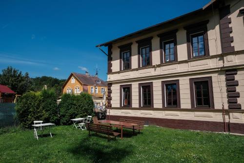 a building with a bench and a table in the yard at Penzion Betty in Okounov