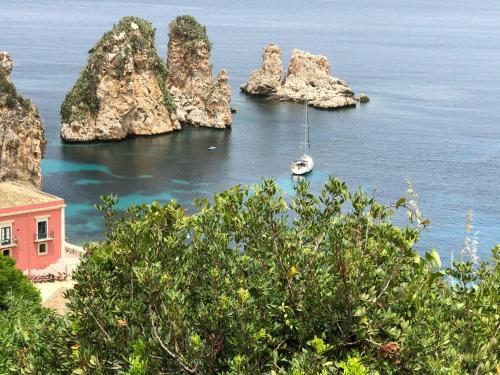 a boat in a bay with rocks in the water at Villa Mariza in Scopello