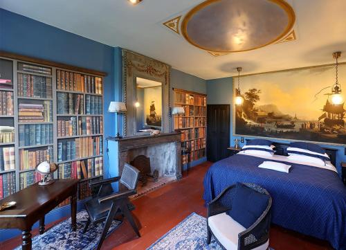a bedroom with a bed and a desk and books at CHATEAU DU GO in Albi