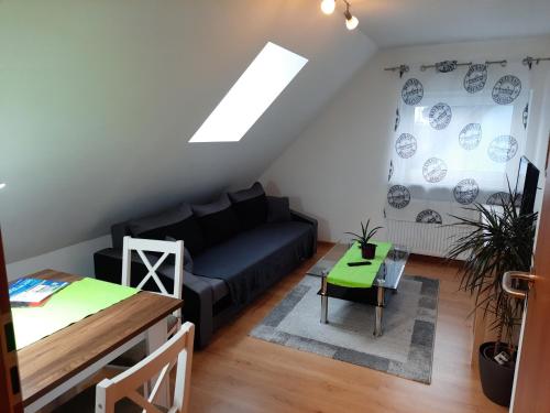 a living room with a black couch and a table at Sarah klein aber fein in Wellesweiler
