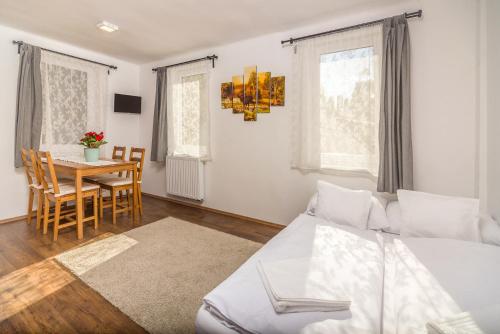 a bedroom with a bed and a table and chairs at Villa Szilva Vendégház in Szilvásvárad