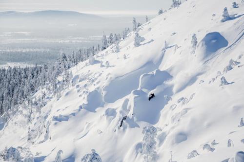 a person is skiing down a snow covered mountain at Ski-Inn PyhäSuites in Pyhätunturi