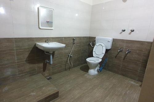 La salle de bains est pourvue de toilettes et d'un lavabo. dans l'établissement Sunshine Stay, à Chennai