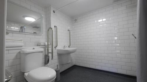 a white bathroom with a toilet and a sink at Mango the Hotel in Haggs