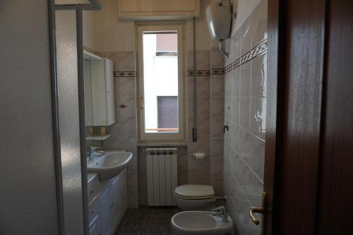 baño con 2 lavabos, aseo y ventana en Appartamento Solilo 3 km da Sestri Levante, en Casarza Ligure