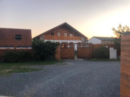 a house with a wooden fence in a yard at Apartmány Diana in Lužice