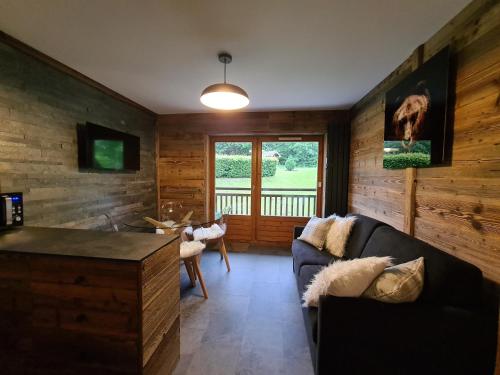 a living room with a couch and a window at Ecrin des Glaciers Combloux in Combloux