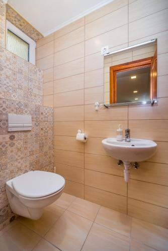 a bathroom with a toilet and a sink at Villa Szilva Vendégház in Szilvásvárad