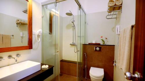 a bathroom with a shower and a toilet and a sink at Kithala Resort - Thema Collection in Tissamaharama
