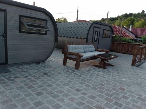 a trailer with a chair and a bench on a patio at Namaste къща в село Камилски дол in Kamilski Dol