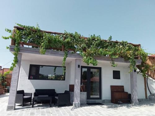 a building with a pergola with plants on it at Namaste къща в село Камилски дол in Kamilski Dol