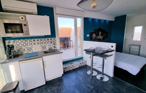 uma cozinha com uma pequena mesa num quarto em Cyrène Port Nature 5 em Cap d'Agde