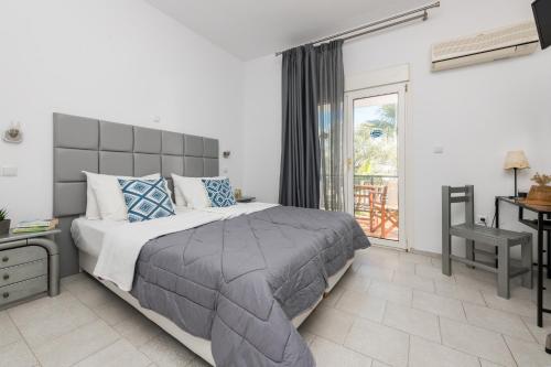 a bedroom with a large bed and a window at Garden Studios Thassos Town in Limenas