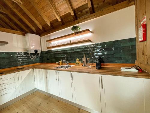 uma cozinha com armários brancos e um balcão de madeira em Mountain Eco Shelters 2 no Funchal