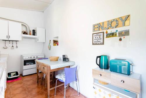 - une petite cuisine avec une table et des chaises dans la chambre dans l'établissement Palheirinho, à Zimbreira