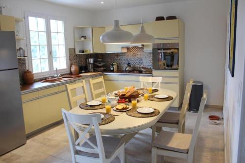 a kitchen with a white table and chairs and a kitchen with at Villa Alexandra in La Croix-Valmer