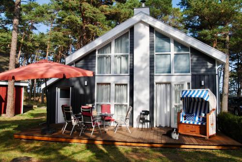 a tiny house with a deck and chairs at Villa Mar Baabe in Baabe