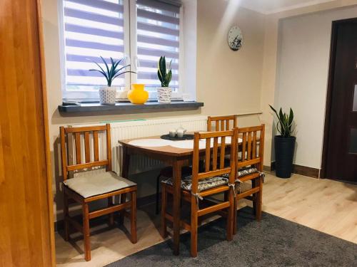 a dining room with a table and chairs and a window at Apartament u Doroty in Augustów