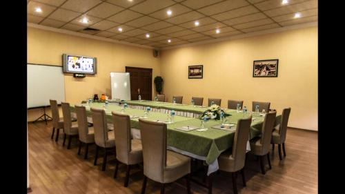 una gran sala de conferencias con una mesa larga y sillas en kristal otel adana en Adana