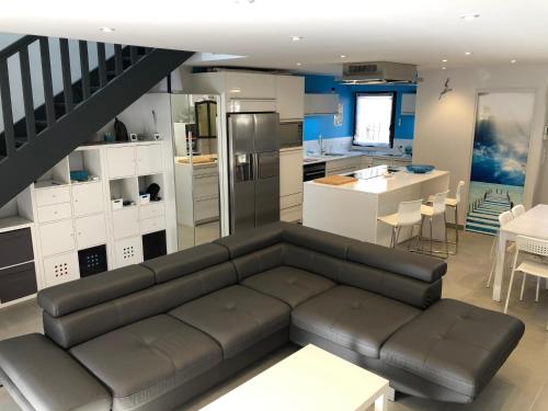 un salon avec un canapé et une cuisine dans l'établissement Villa ZEN, au Grau-du-Roi