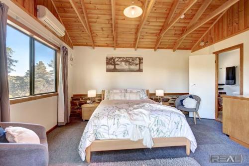 um quarto com uma cama e uma grande janela em HighRoost Bed & Breakfast accomodation - rural escape em Red Creek