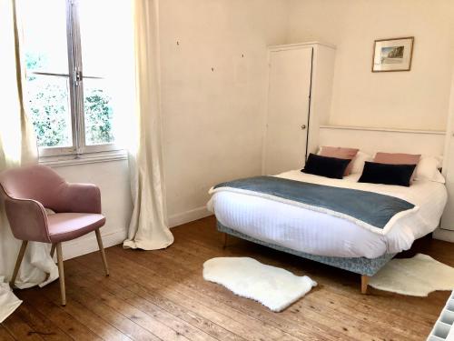 une chambre avec un lit, une chaise et une fenêtre dans l'établissement Villa vue mer avec acces direct a la plage, à Varengeville-sur-Mer