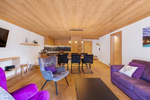 格里門茨的住宿－Chalet Larchwood by Mrs Miggins，客厅配有紫色沙发和桌子
