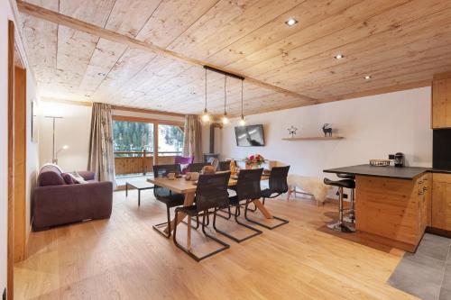a dining room and living room with a table and chairs at Chalet Larchwood by Mrs Miggins in Grimentz