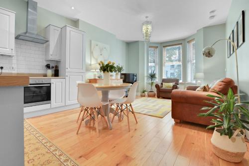 a kitchen and living room with a table and chairs at Quay House, North Coast 6 bedroom holiday home in Ballycastle