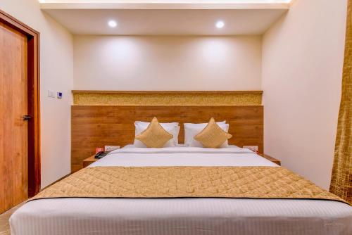 a bedroom with a large bed with a wooden headboard at Zip By Spree Hotels Brookefield in Bengaluru