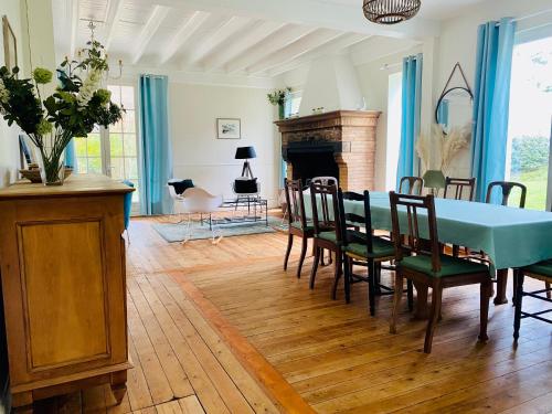 une salle à manger avec une table et des chaises et une cheminée dans l'établissement Villa vue mer avec acces direct a la plage, à Varengeville-sur-Mer