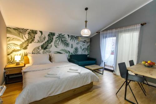 a bedroom with a large white bed and a table at Studio Apartments Villa 24 in Tirana