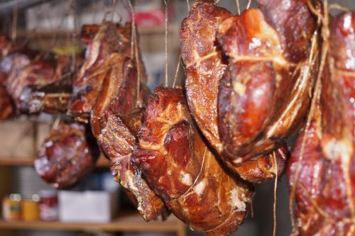 a bunch of bacon hanging in a store at Privat Bohemia in Šatov