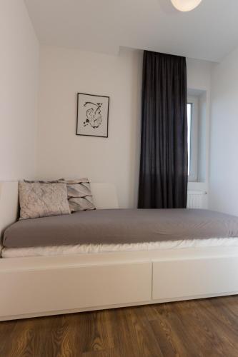 a bedroom with a large white bed with a window at Lenzo Apartments Wieliczka in Wieliczka