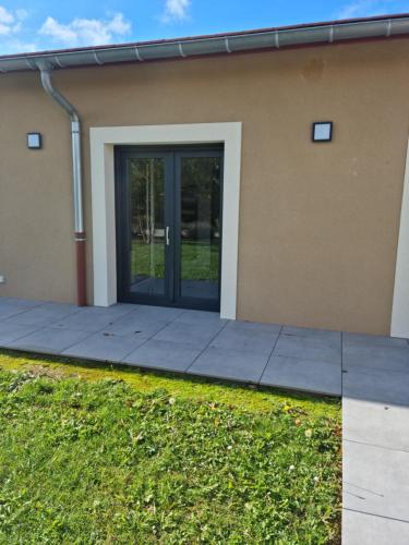eine Glastür eines Hauses mit Bürgersteig in der Unterkunft Albizia bis in Pintheville