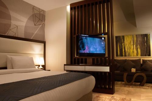 a bedroom with a bed and a flat screen tv at Seas Hotel Amman in Amman