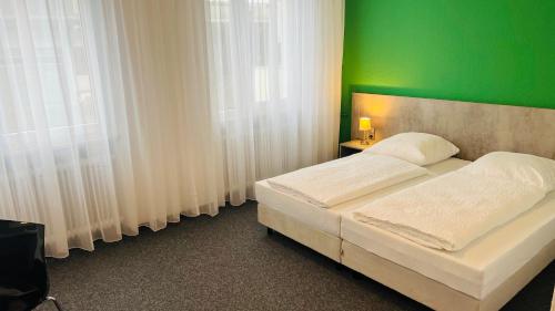 ein Schlafzimmer mit einer grünen Wand und einem Bett in der Unterkunft Creativ Park Hotel in Nürnberg