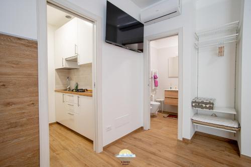 a small kitchen with white cabinets and a bathroom at IL CENTRO LUXURY SUITES in Bari