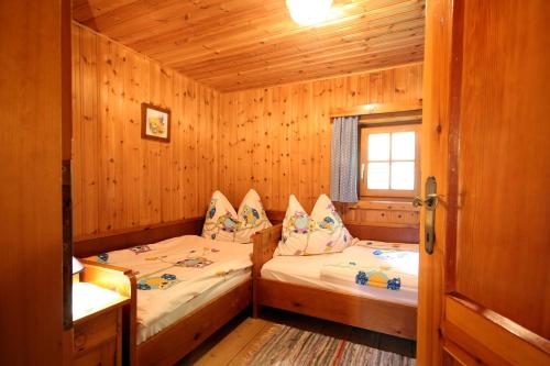 a bedroom with two beds in a wooden cabin at Almliesl EMBA-605 in Embach