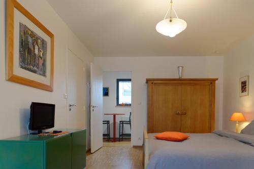 - une chambre avec un lit et un bureau avec une télévision dans l'établissement Studio Les Terrasses de Kerangall, à Brest