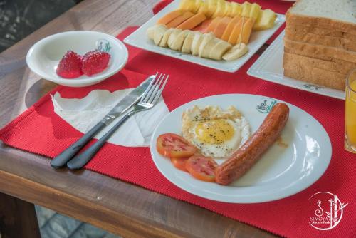 a table with a breakfast plate of eggs sausage and tomatoes at Simoya Nature Park in Dambulla