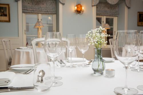 
a table topped with white plates filled with wine glasses at Schackenborg Slotskro in Tønder
