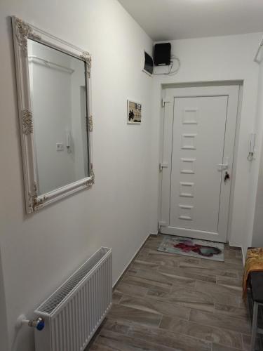 a mirror on a wall next to a door at Valentin Apartman in Makó