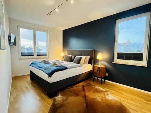 a bedroom with a bed and two windows at Ferienwohnung Strandgold in Binz