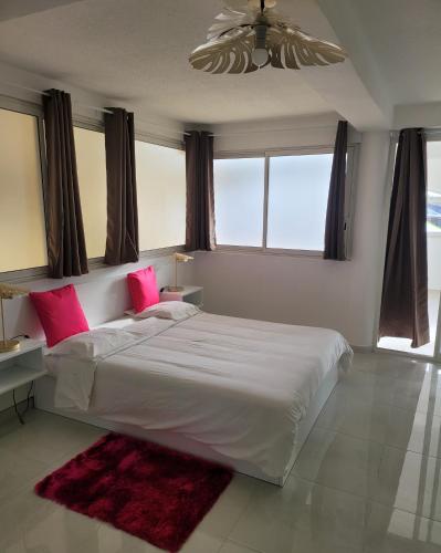 sypialnia z dużym białym łóżkiem z różowymi poduszkami w obiekcie Hello Guyane (2), Suite Luxury, 5 étoiles w mieście Kajenna